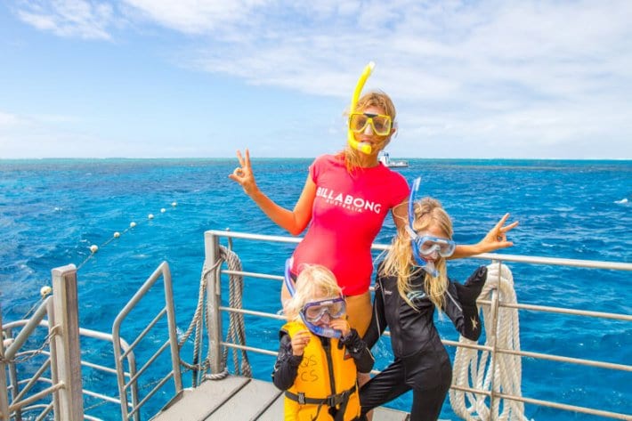family posing to camera with snorkels on