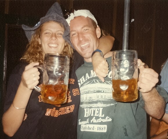 man and pistillate   holding up   glasses of beer