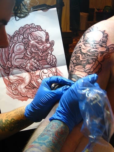 a person getting their arm tattooed