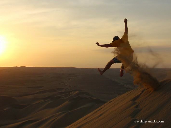person jumping off the sand dunes at Huacachina sunset 