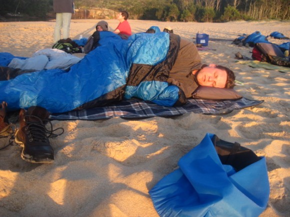a man sleeping on the beach
