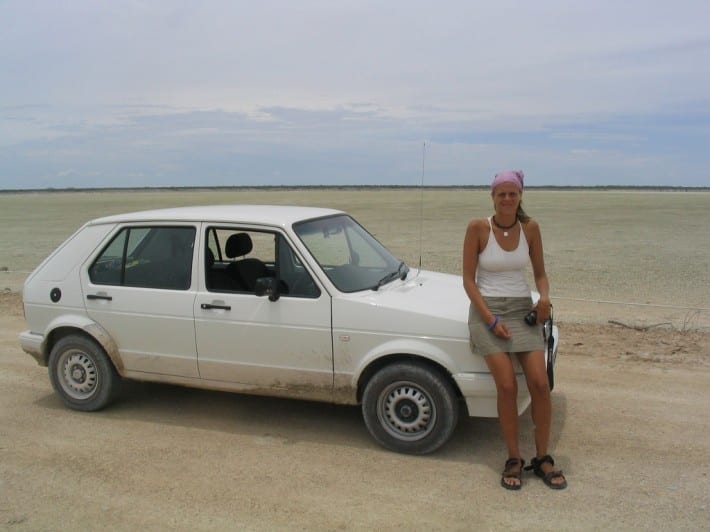 caz in front of car on salt plain in etosha