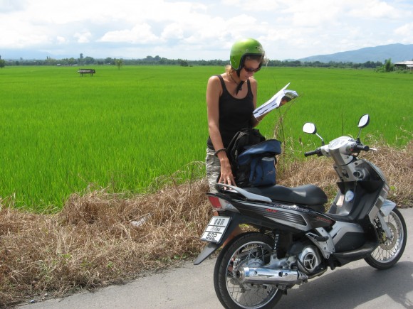 a woman standing next to a motorbike