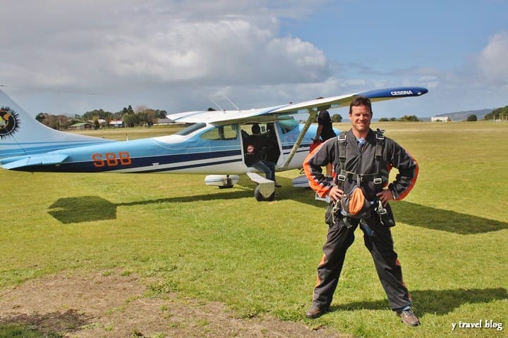 craig in front of plane with skydiving suit on