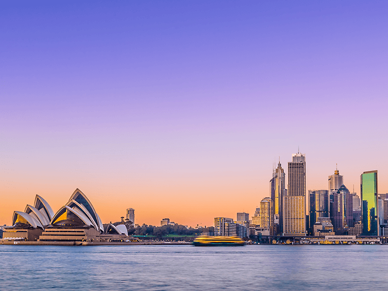 Opera house ad buildings on sydney harbour at sunset