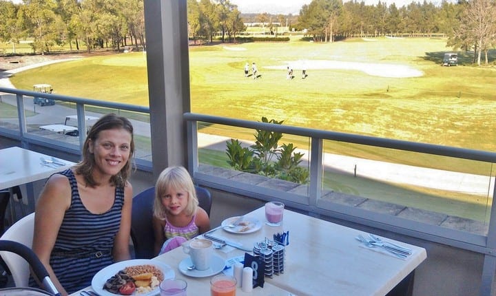 woman and girl sitting at breakfast table with golf course views