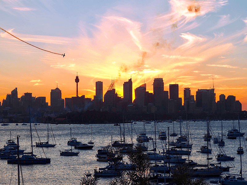 sydney  skyline at sunset with boats in front 