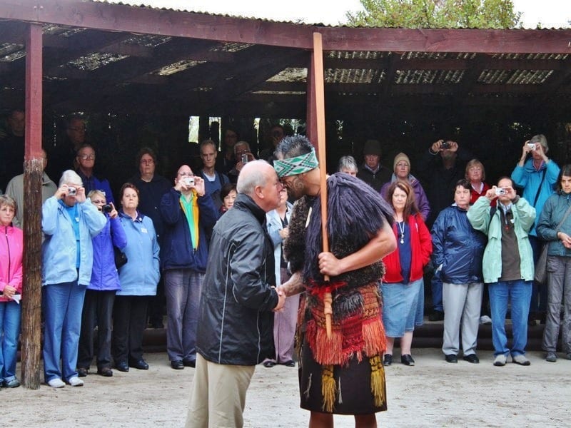 two men rubbing foreheads in traditional maori greeting