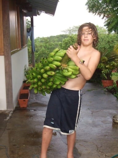 a boy holding up bananas