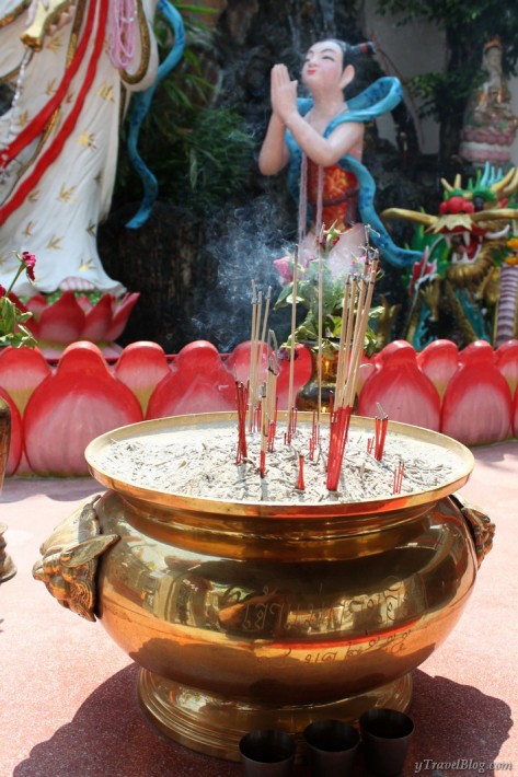statue of person praying with incense burning in bowl Chinatown Bangkok temple