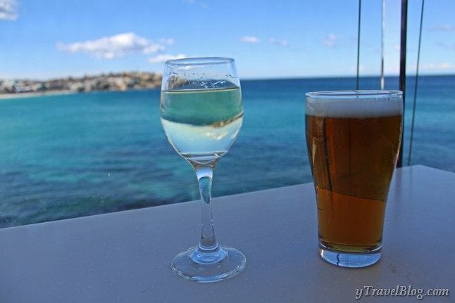 beer and wine on table with view of bondi beach