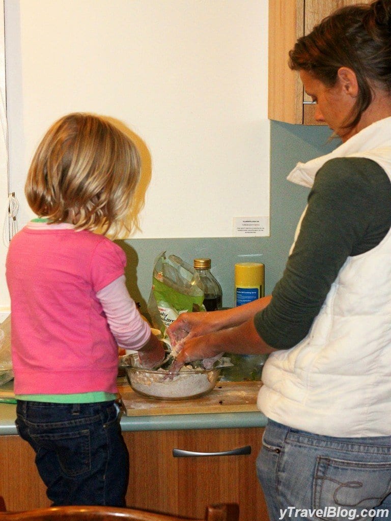 a woman and a little girl cooking food