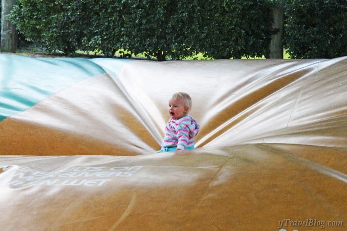 a child sitting on a blow up jumping pad