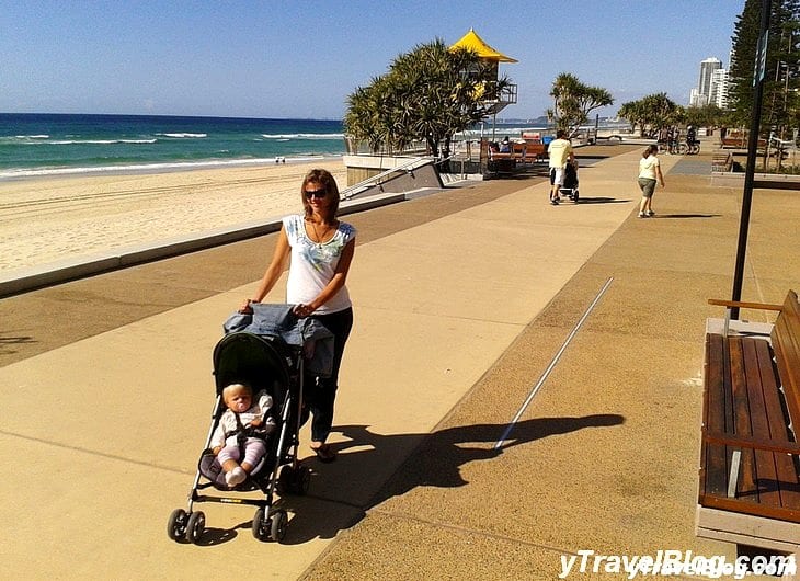 a woman pushing a stroller on a pathway