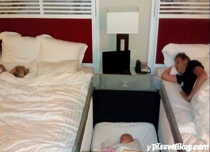a woman and a baby sleeping in a hotel room