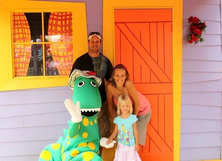 family standing next to a fake dinosaur
