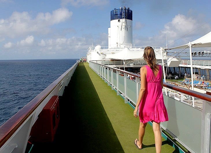 a woman walking on the top deck of a cruise ship