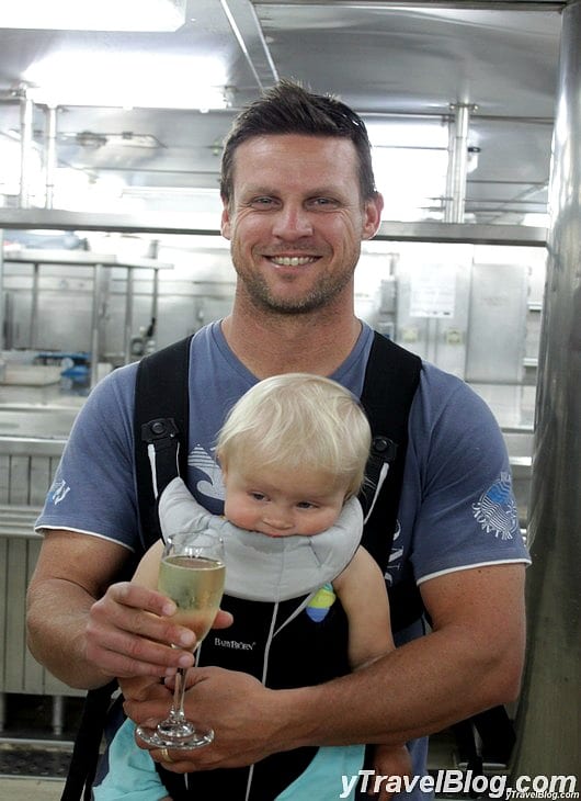 a man holding a baby in a kitchen