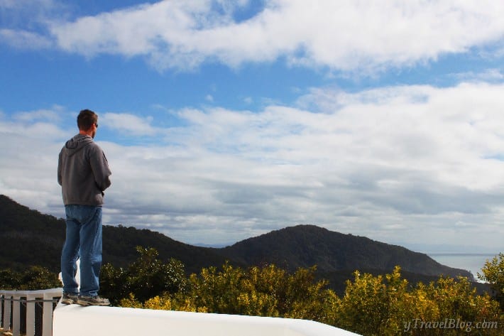 man standing on ledge looking at view
