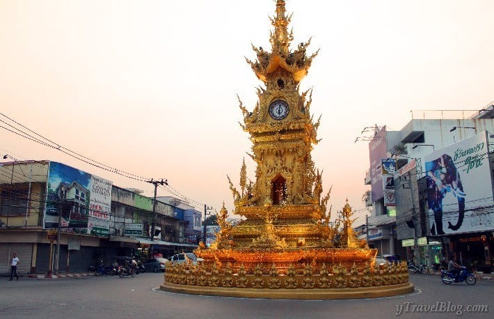a golden monument in the middle of the road 