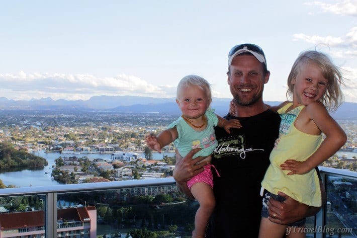 man holding two children on balcony with gold coast hinterland views