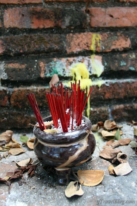 bowl of incense in front of brick wall