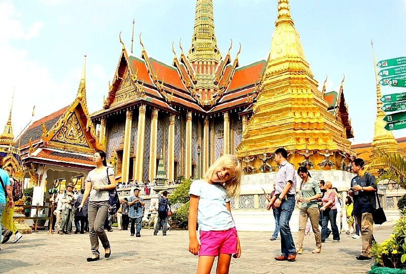 girl standing in front of the golden temple bankgkok