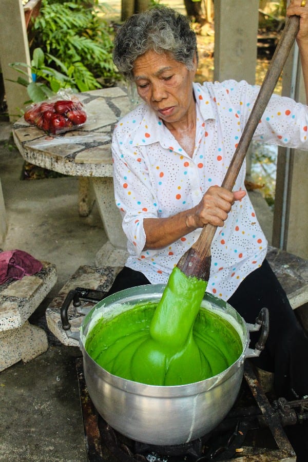 woman stirring green liquid in a pot