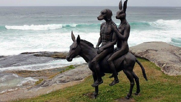 sculpture of dog and rabbit on a donkey on the cliff top
