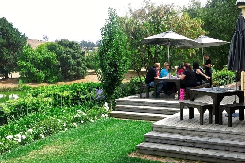people sitting at picnic tables in a garden