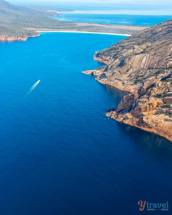 aerial view of boat cruising into Wineglass Bay 