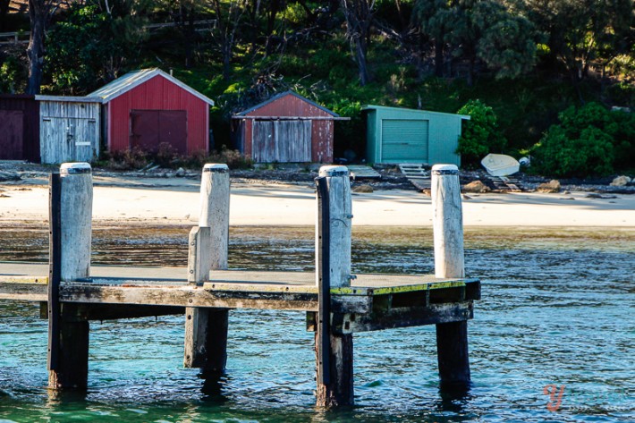 jetty with colored sheds on sand
