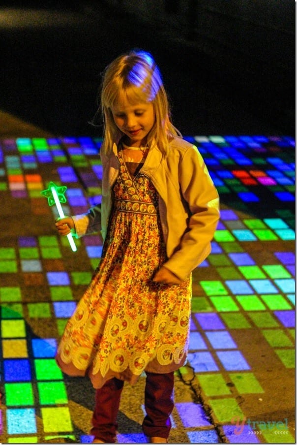 a girl standing on colorful lights