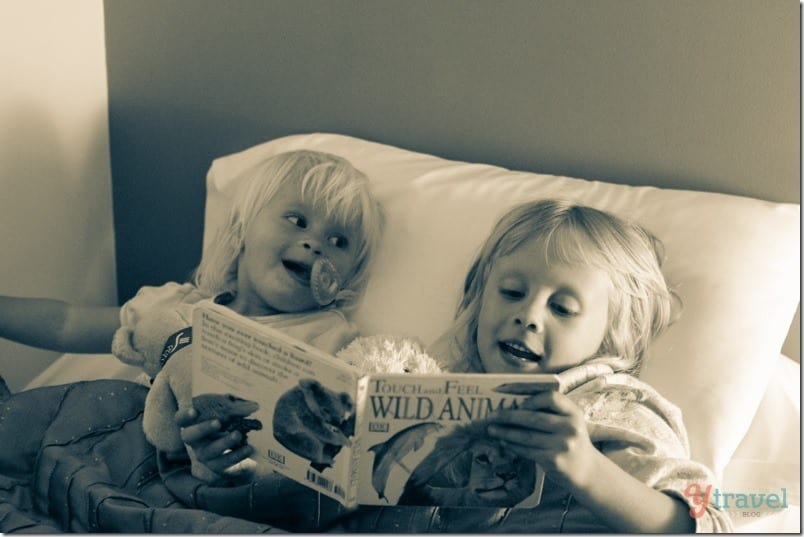 little girls lying in bed reading