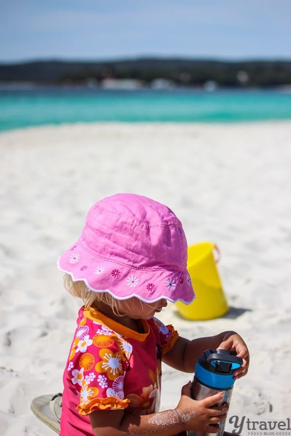 A little girl sitting at a beach
