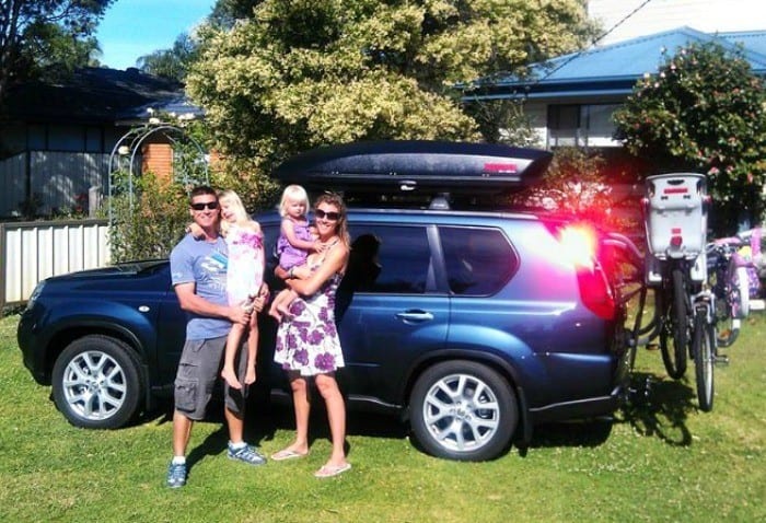 a family standing next to a car