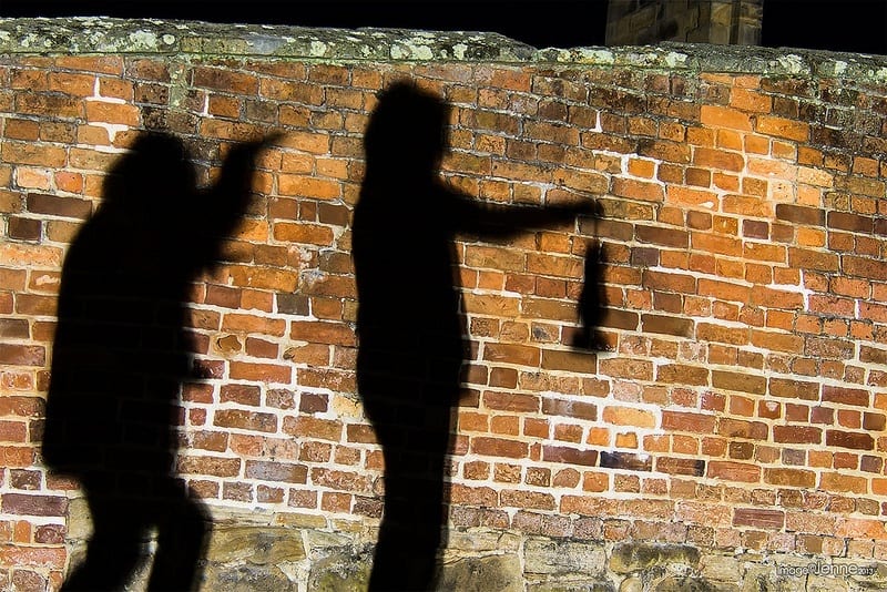 shadows of people on a brick wall