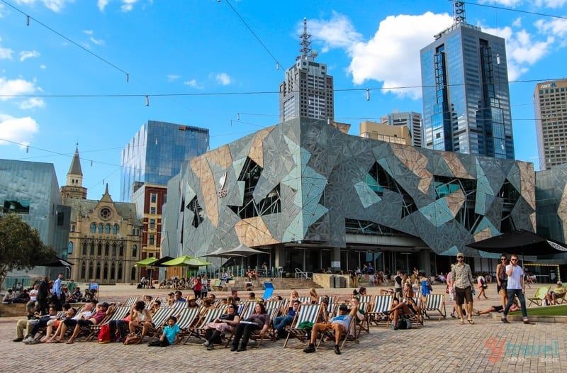 people sitting on beach chairs at Federation Square