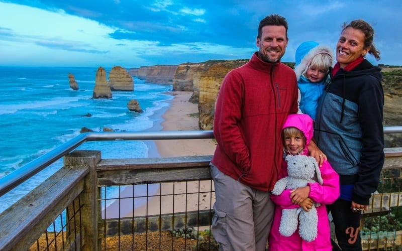family posing for camera with view of Twelve Apostles behind them