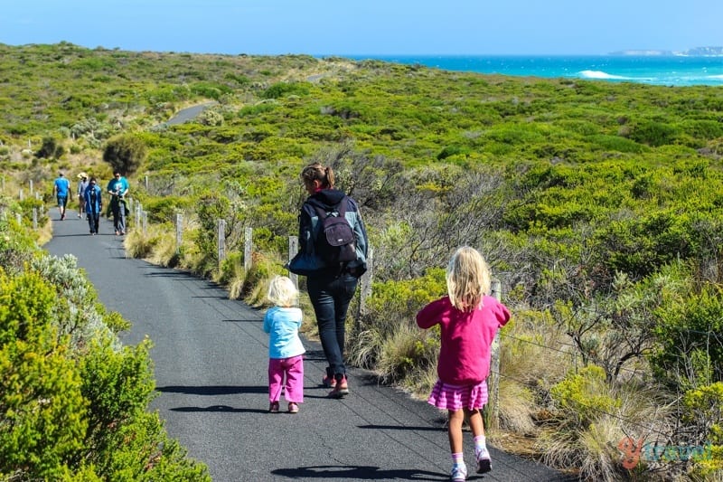 family walking on trail with views of ocean