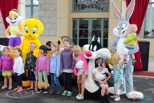a group of kids standing with people dressed up as characters