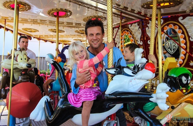 man holding a child on a carousel 