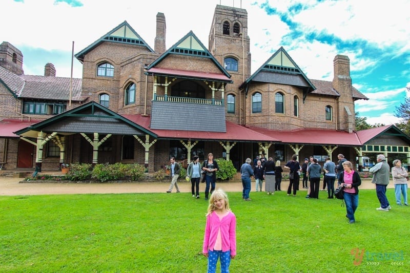 girl standing out the front of elaborate Booloominbah estate 