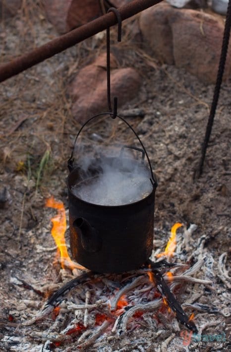 boiling bot of water hanging over a fire