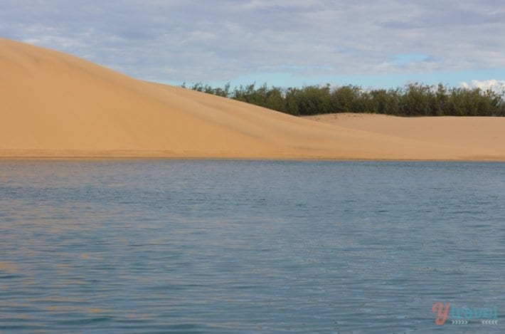 sand dunes next to water