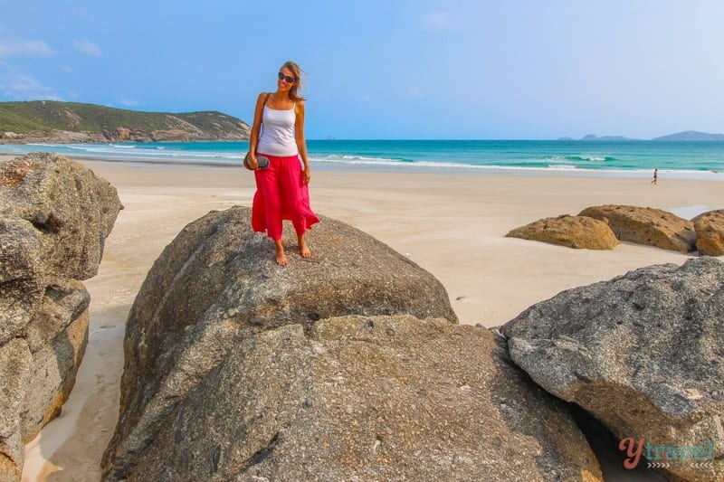 lady standing on giant rock on Squeaky Beach,