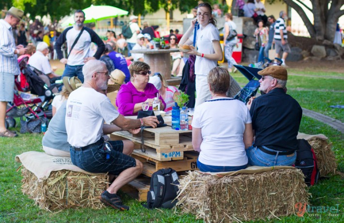 people sitting on hay stacks around a table