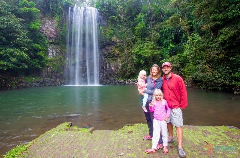 family posing in front of Millaa Millaa Falls, spilling into a pool of water