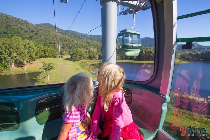girls looking out window of Skyrail passing another gondola