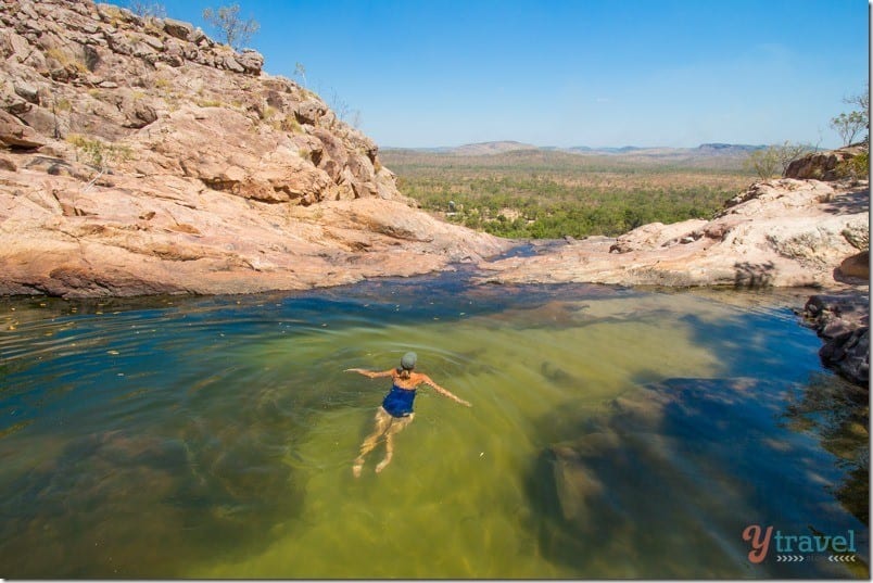 woman swimming in waterhole overlooking valley at Gunlom FAlls,